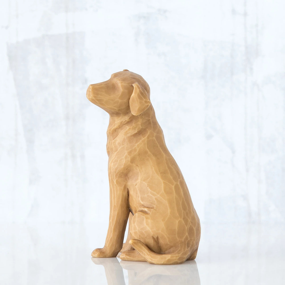 Golden dog figurine sitting to the side - all white background