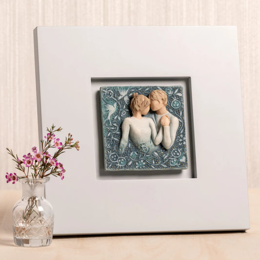 Willow Tree Duet, 10”sq hand-painted dove gray wood frame, with inset bas-relief resin plaque of embracing couple, surrounded by nature, blue ombré background with gold leaf