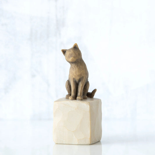 Golden cat figurine sitting on white rock