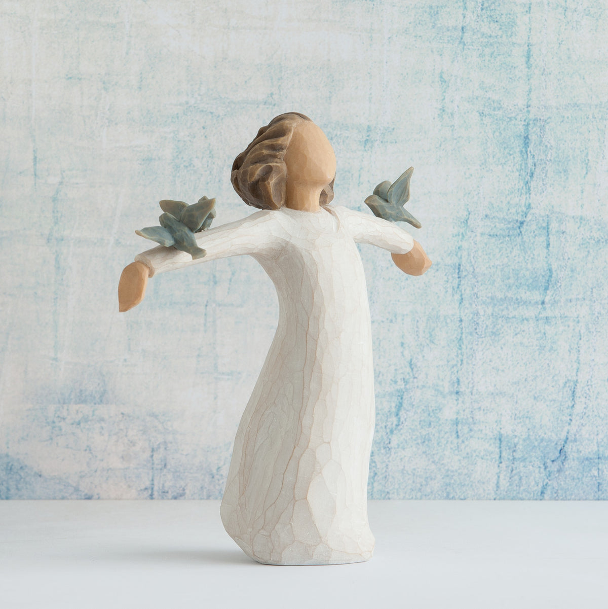 Willow Tree Happiness, 5.5”h hand-painted standing resin figure in cream dress, three bluebirds perched on outstretched arms, in front of sky blue painting