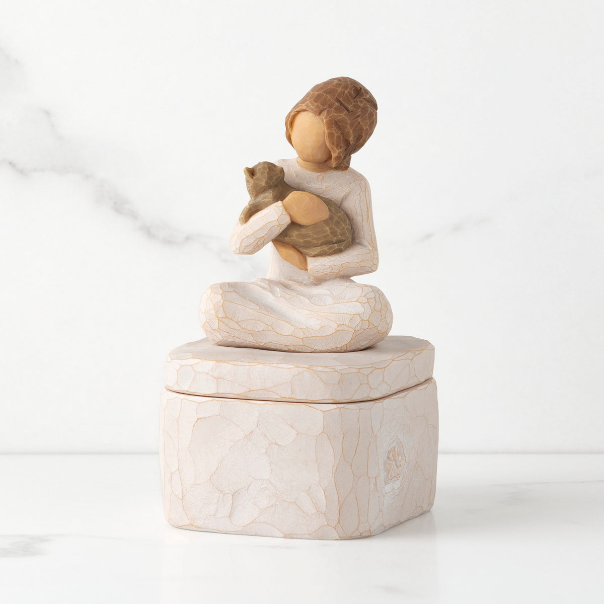 Front: cream square resin box with lid, 3-D figure of seated girl holding cat atop lid