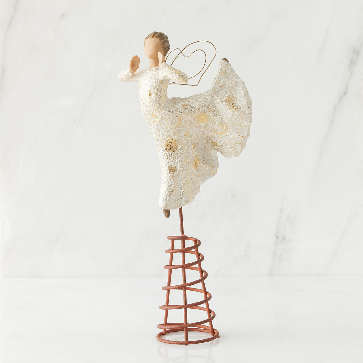 Angel figurine standing on red stand wearing white dress