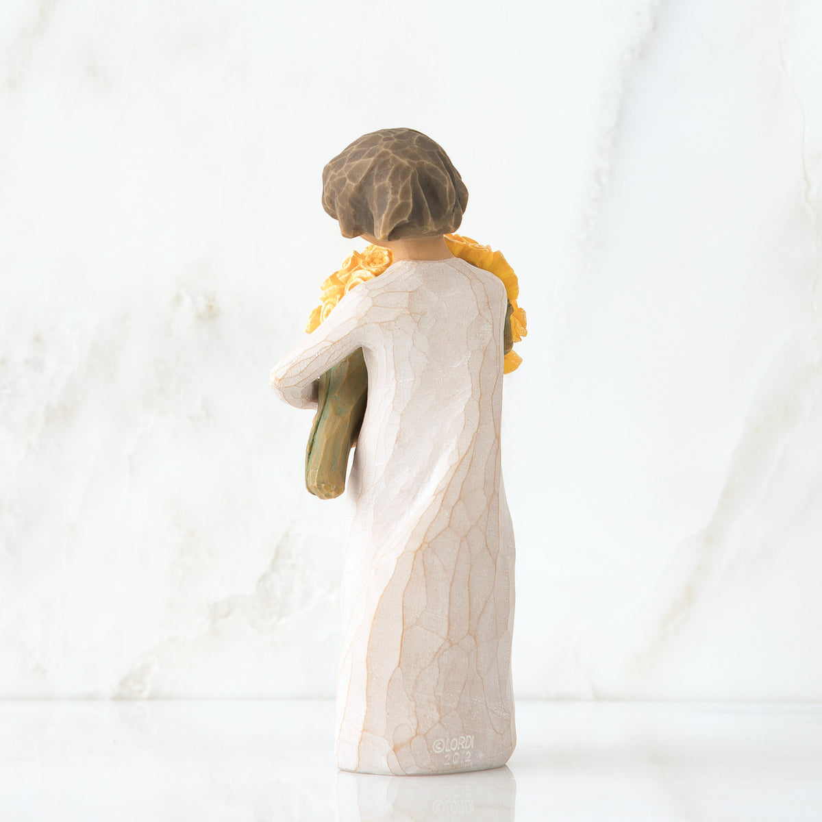 Back view of little girl with short brown hair holding a large bouquet of yellow roses