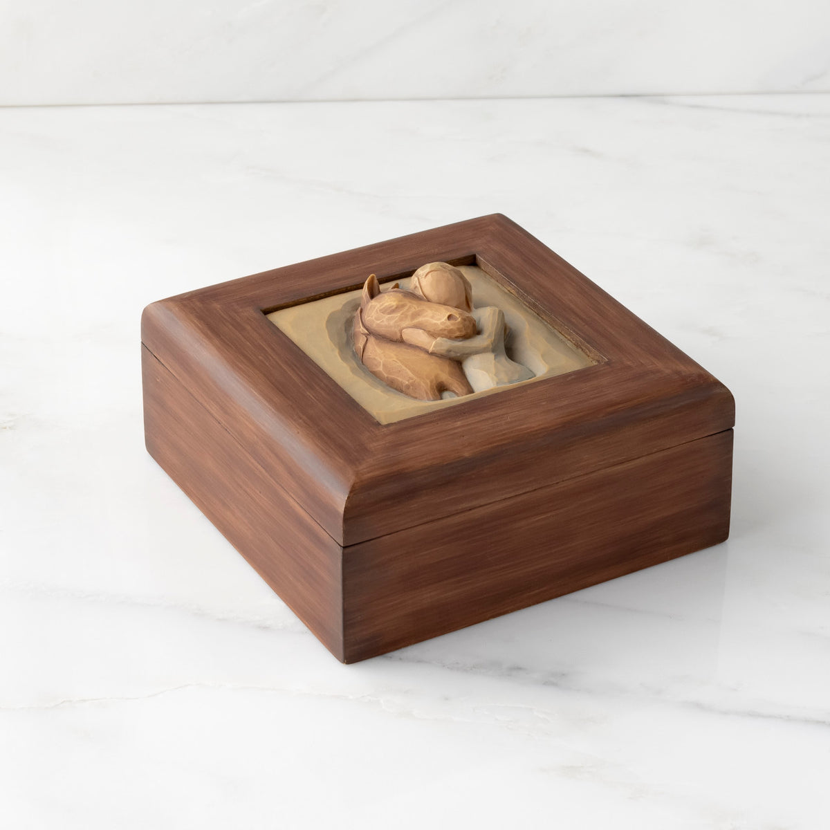 Top down view: Dark brown square wood box with hinged lid, carving on lid of female in green dress, with arms embracing reddish-color horse