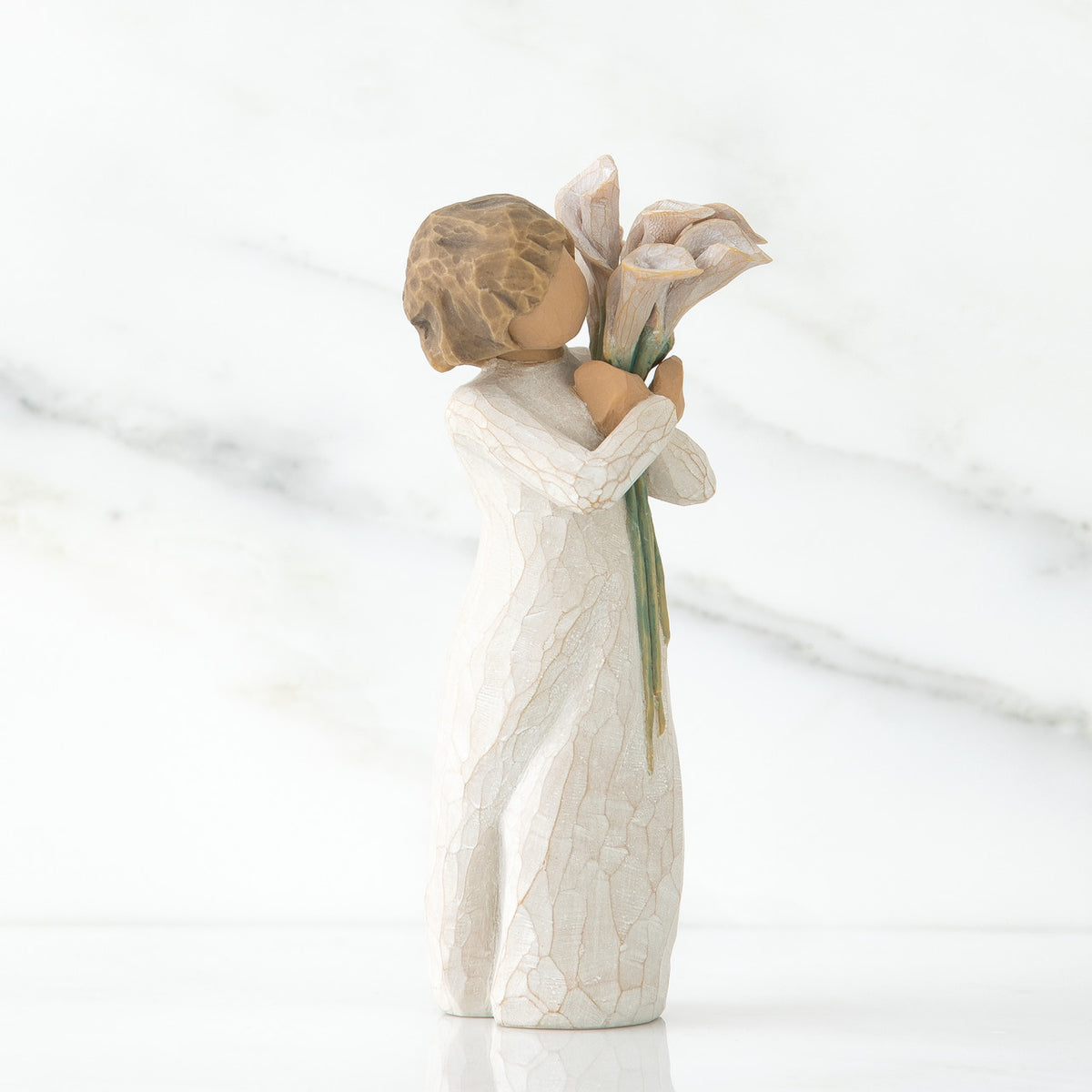 Left side view of lIttle girl with short brown hair holding a cluter of white calla lilies