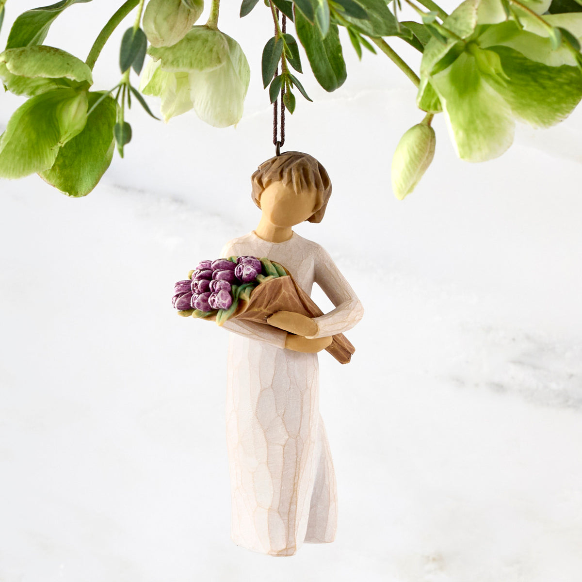 Figure in cream dress, holding large bouquet of purple tulips. Hook and loop affixed to figure’s head