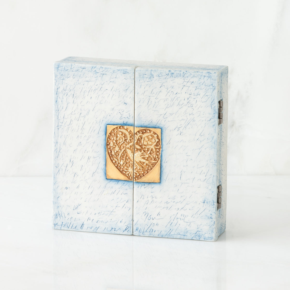 White/blue box with gold heart pendant centered