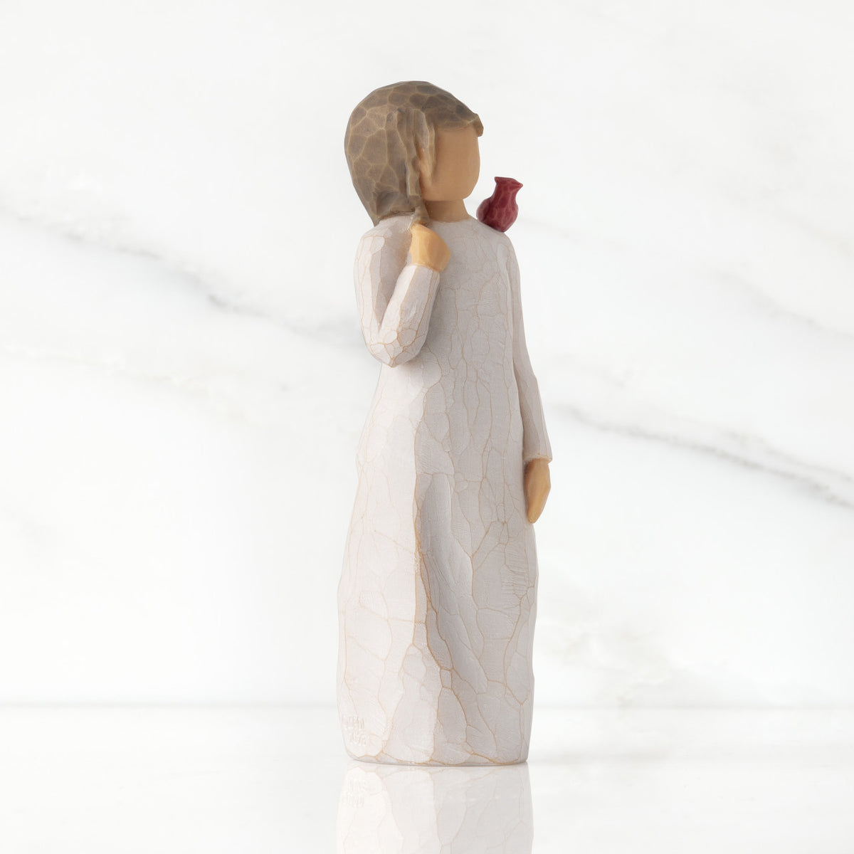 Right side of standing figure in cream dress with cardinal red bird perched on shoulder