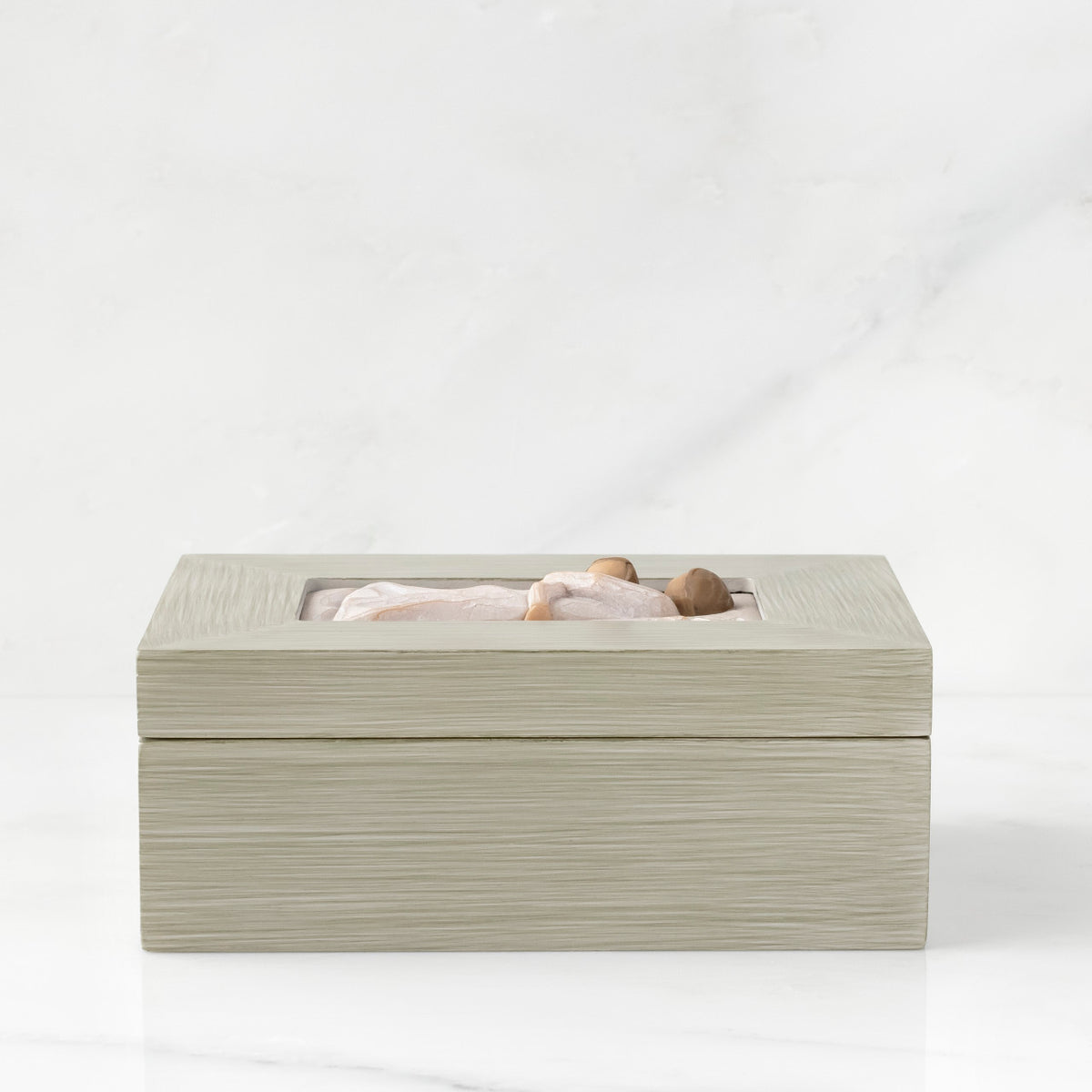 Side view: Light gray rectangular wood box with hinged lid, carving on lid of female and child embracing in cream dresses