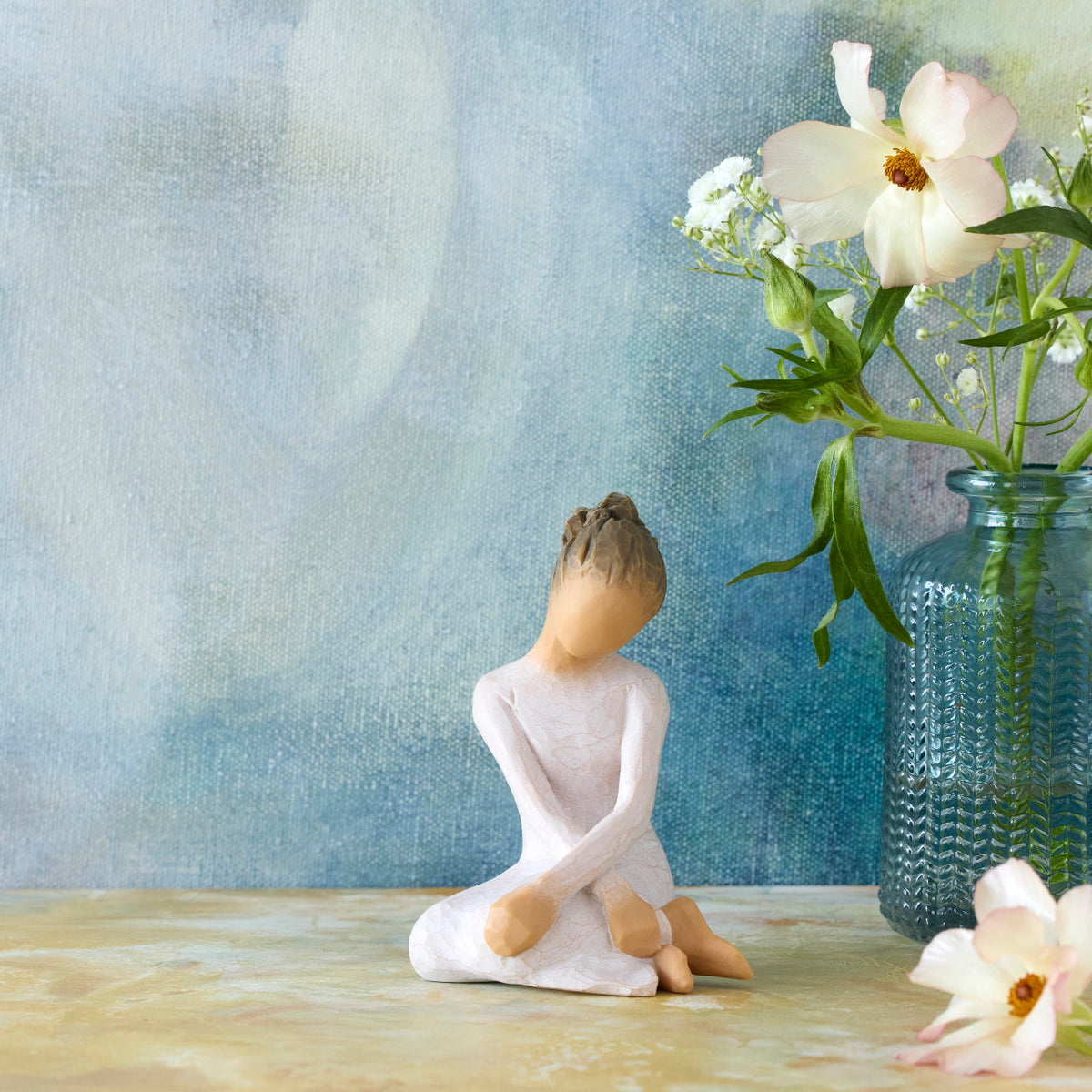 Willow Tree Serenity, 3.5”h hand-painted seated figure in cream dress, arms crossed in balletic pose, in front of deep blue painting