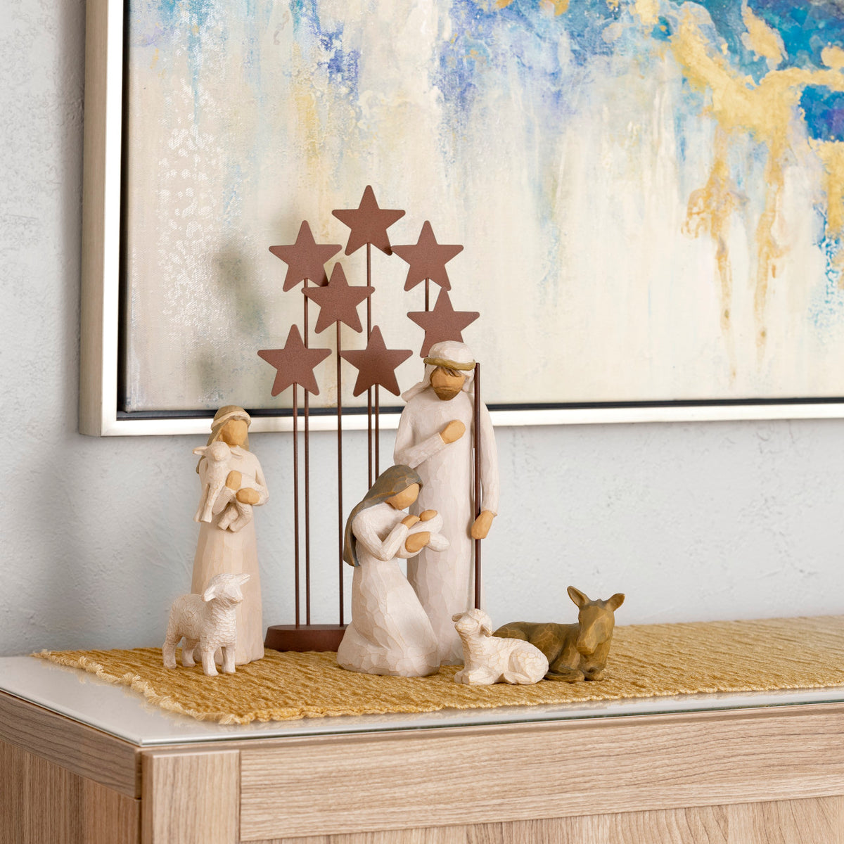 Display of Nativity figures atop gradated mustard color table runner, 2 ft by 5 ft gauze fabric, shown on top of cabinet