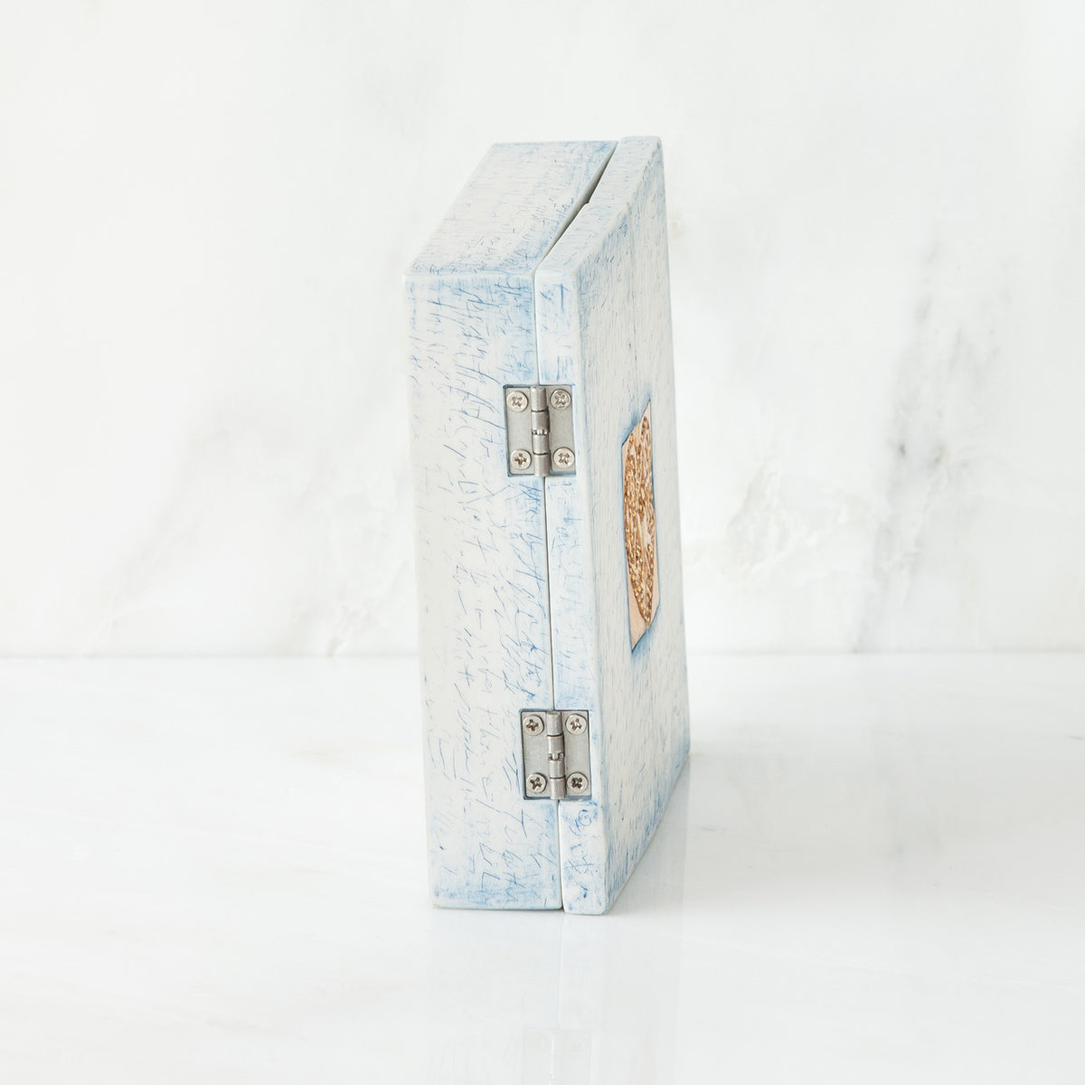 Side view of light blue/white wooden book standing up white background